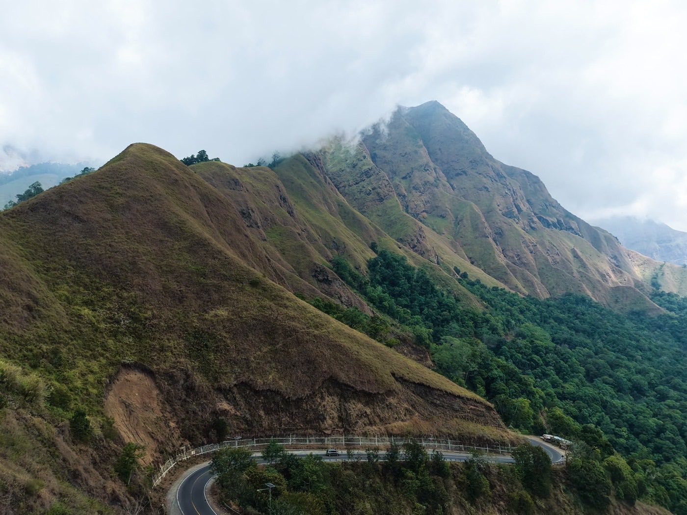 A car on the winding coast road through the Lombok hills, the kind of drive a transfer covers.